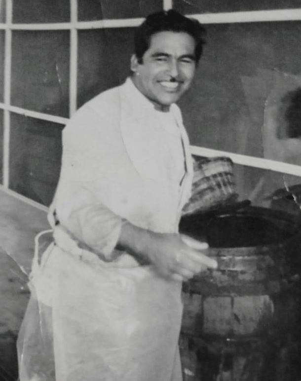 Original faded black-and-white photograph of the sorghum master distiller